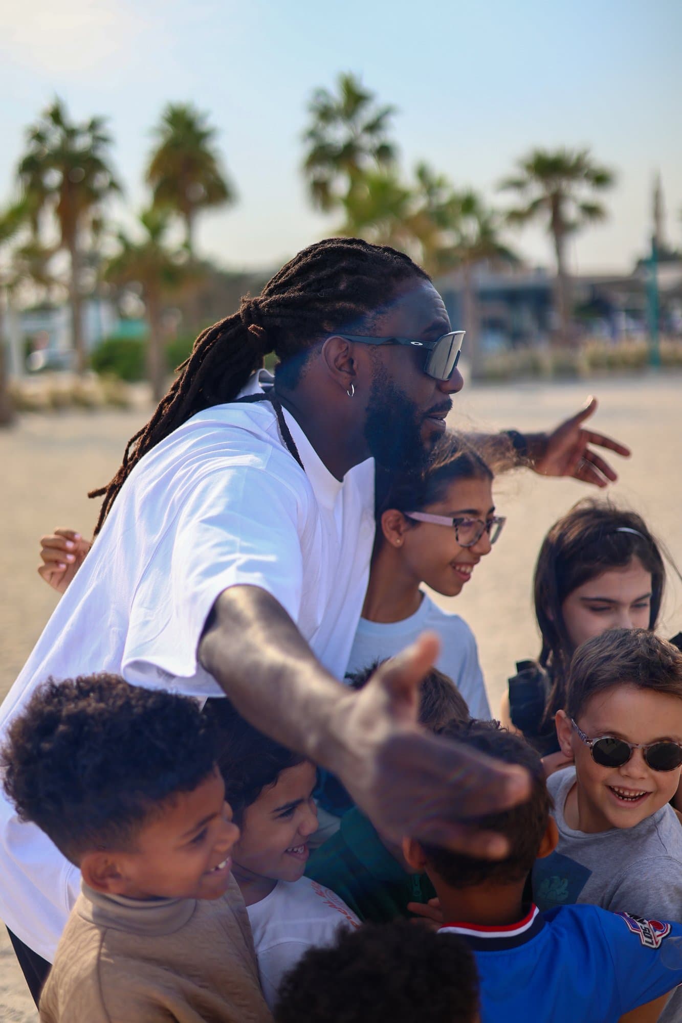 Coach Ronald avec des enfants sur la plage à Dubaï